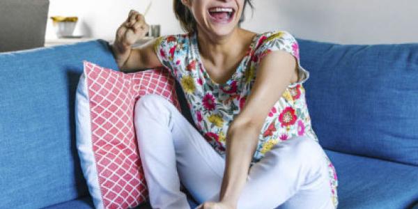 Girl laughing and sitting on couch